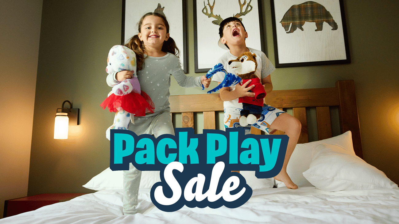 kids  holding plush toys jumping on bed